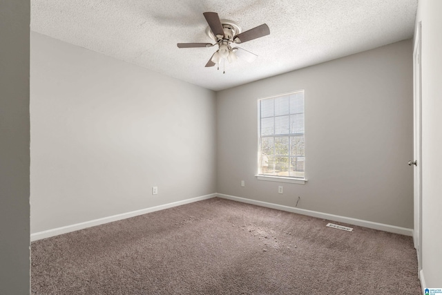 empty room featuring a textured ceiling, baseboards, carpet, and a ceiling fan