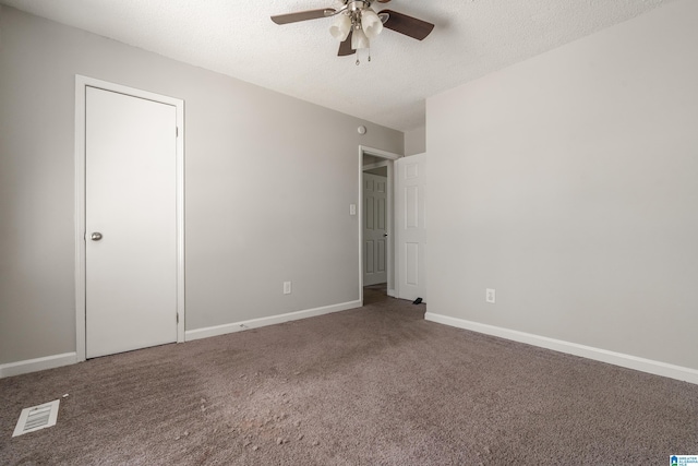 unfurnished bedroom featuring a textured ceiling, baseboards, and carpet floors