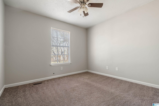 carpeted spare room with baseboards, visible vents, a textured ceiling, and ceiling fan