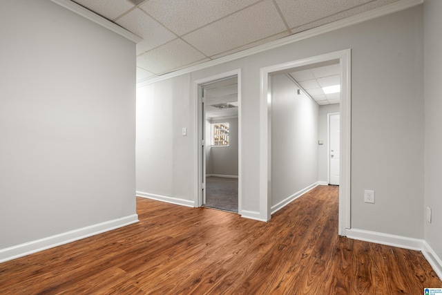 unfurnished room with a drop ceiling, baseboards, and dark wood-type flooring