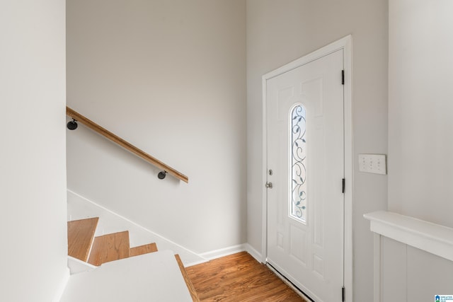 foyer entrance featuring stairway, baseboards, and wood finished floors