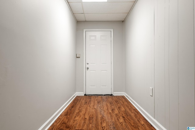 entryway featuring baseboards, a paneled ceiling, and dark wood-type flooring