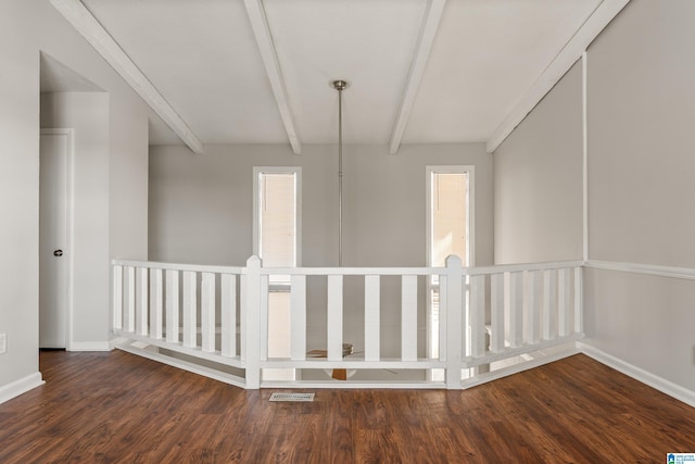 interior space with wood finished floors, visible vents, baseboards, plenty of natural light, and beamed ceiling