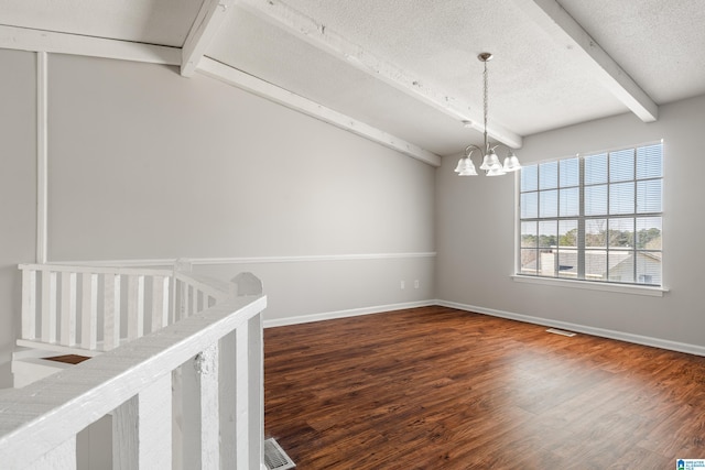 spare room featuring a chandelier, baseboards, a textured ceiling, and wood finished floors