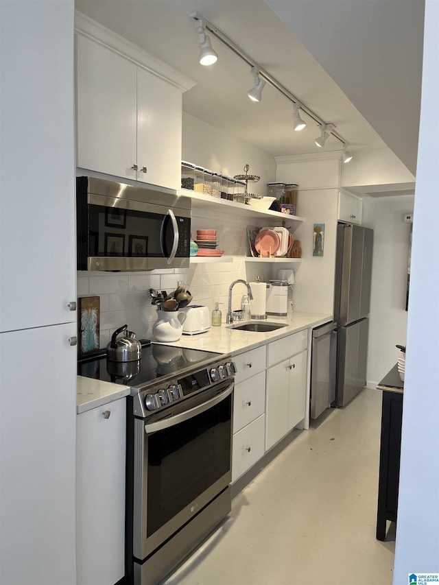 kitchen featuring open shelves, a sink, white cabinets, appliances with stainless steel finishes, and backsplash