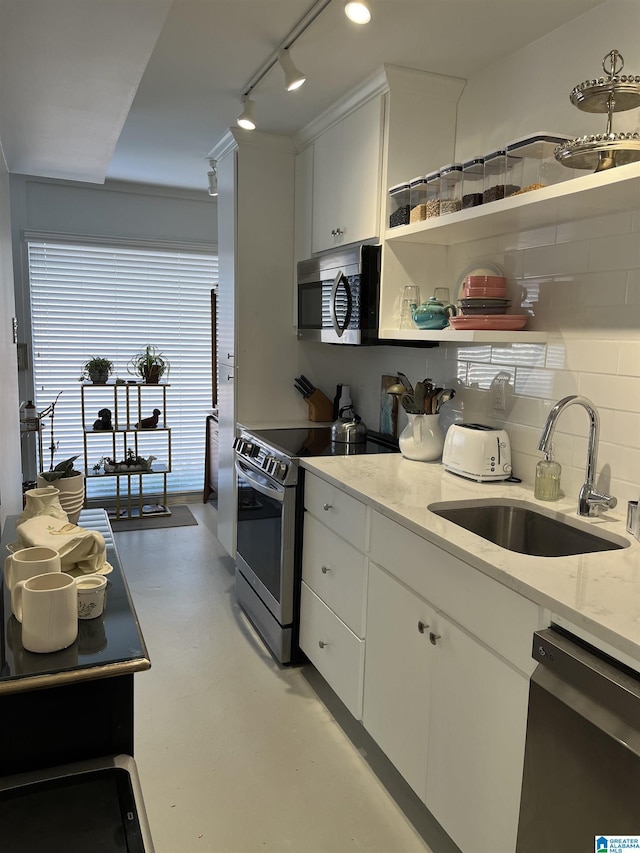 kitchen featuring backsplash, white cabinetry, stainless steel appliances, and a sink