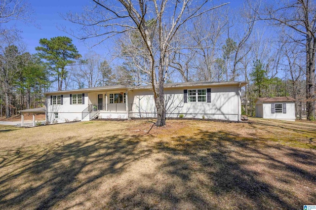 single story home featuring a storage unit, an outdoor structure, and a front lawn