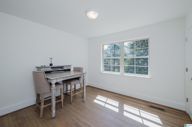 office area featuring wood finished floors, visible vents, and baseboards