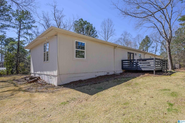 view of side of home featuring crawl space, a wooden deck, and a yard