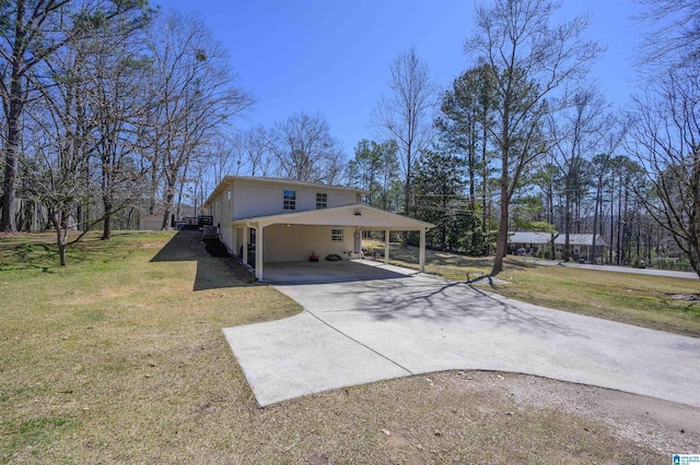 view of side of property with a carport, a lawn, and driveway