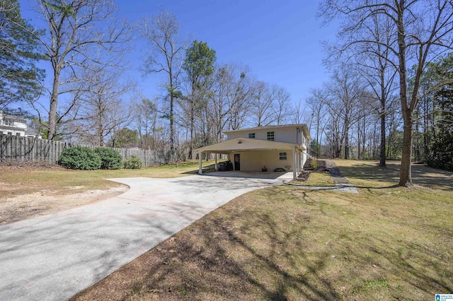 view of property exterior featuring concrete driveway, a yard, and fence