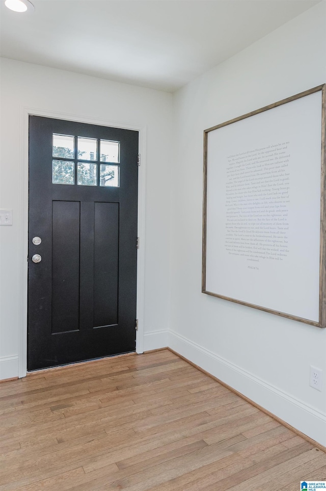 foyer with baseboards and light wood-style floors