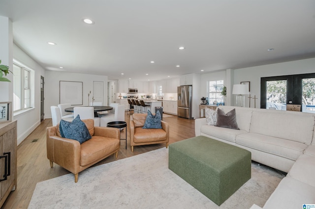 living area featuring recessed lighting, light wood-type flooring, and baseboards