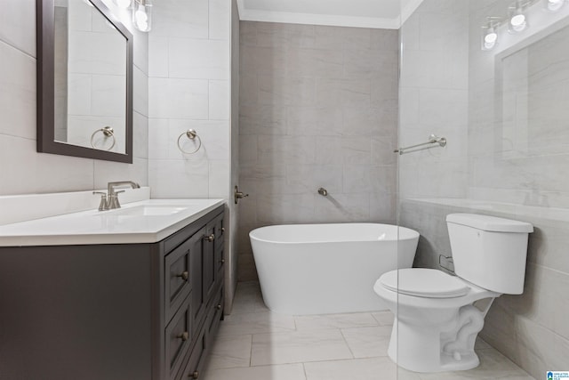 full bathroom featuring toilet, a freestanding bath, tile walls, and vanity