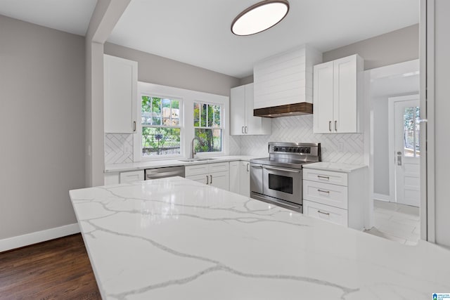 kitchen featuring tasteful backsplash, white cabinetry, stainless steel appliances, and a sink