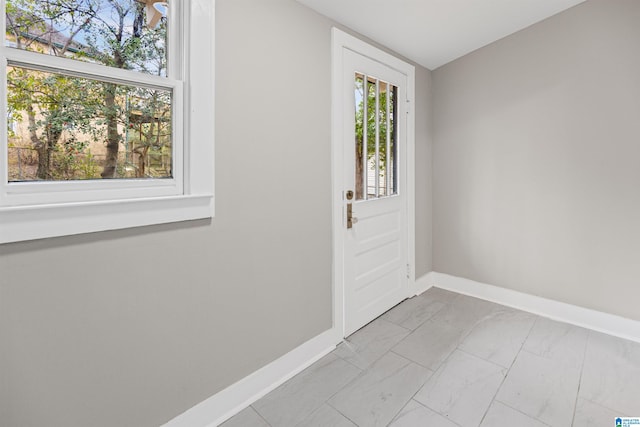 entrance foyer with baseboards and marble finish floor