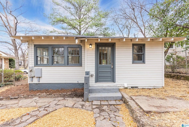 view of front of home with fence and crawl space