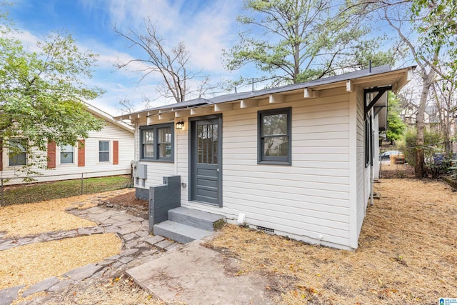 view of front of home with entry steps, fence, and crawl space