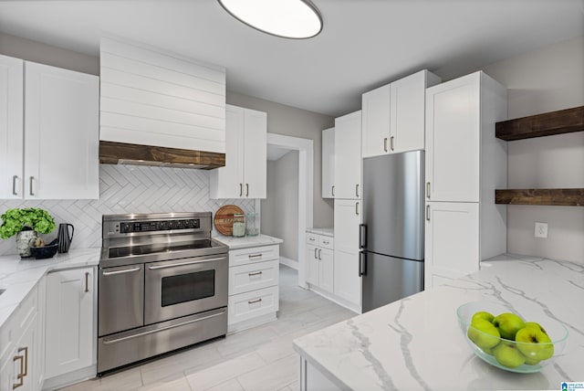 kitchen with open shelves, tasteful backsplash, appliances with stainless steel finishes, and white cabinetry