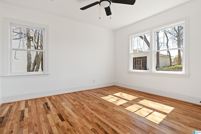 spare room with wood finished floors, baseboards, and ceiling fan