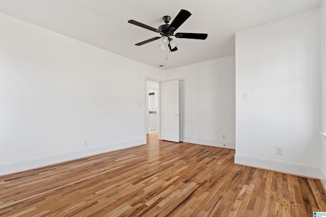 spare room with light wood-style flooring, a ceiling fan, and baseboards