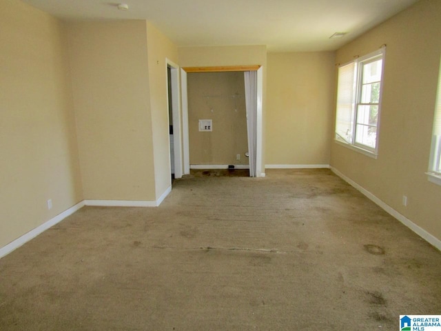 empty room featuring baseboards and carpet floors