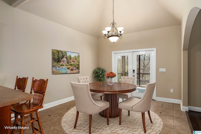 tiled dining room featuring baseboards, lofted ceiling, french doors, arched walkways, and a notable chandelier