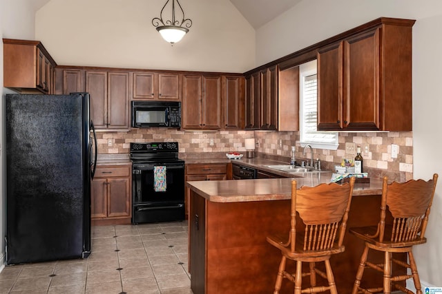 kitchen with backsplash, vaulted ceiling, a peninsula, black appliances, and a sink