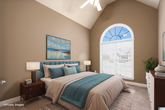 carpeted bedroom featuring baseboards, high vaulted ceiling, and a ceiling fan