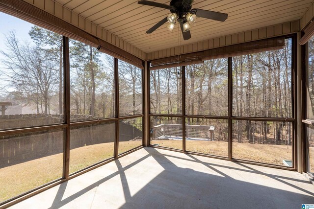 unfurnished sunroom with a wealth of natural light, ceiling fan, and wooden ceiling