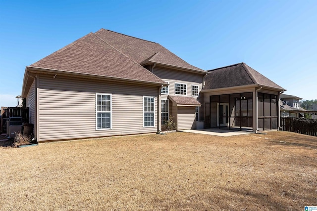 back of house featuring a shingled roof, fence, a yard, a sunroom, and a patio area