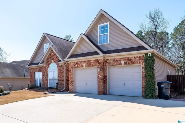 traditional-style house with brick siding, concrete driveway, roof with shingles, and fence