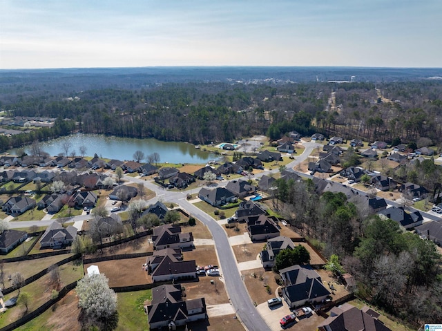 drone / aerial view featuring a residential view, a view of trees, and a water view