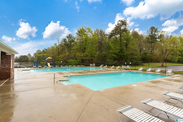 pool with a patio and fence