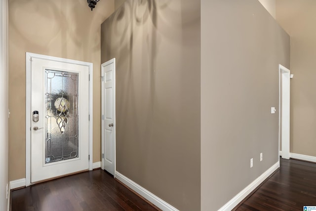 foyer with dark wood finished floors and baseboards