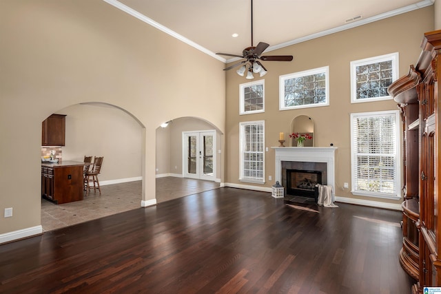 living room featuring a fireplace, wood finished floors, visible vents, and arched walkways