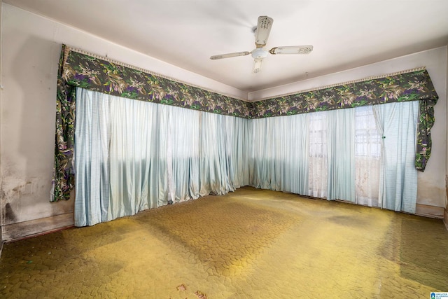 carpeted spare room featuring ceiling fan