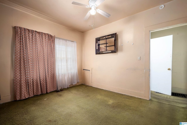 carpeted empty room with visible vents and a ceiling fan