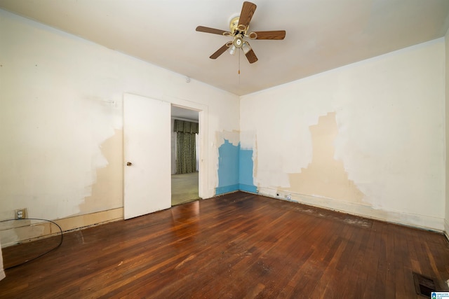 empty room featuring visible vents, a ceiling fan, and hardwood / wood-style flooring