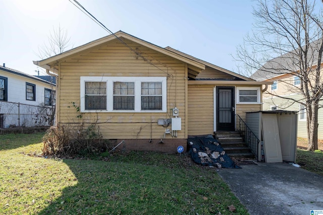 bungalow-style home featuring crawl space, entry steps, a front lawn, and fence