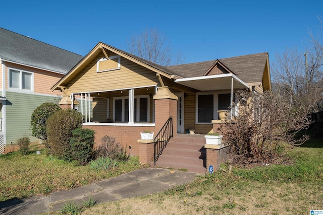 bungalow-style house with brick siding and covered porch