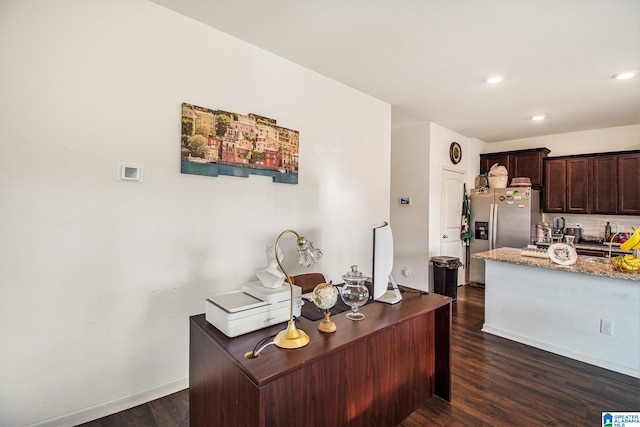 kitchen featuring light stone counters, dark brown cabinets, dark wood-style floors, and stainless steel refrigerator with ice dispenser