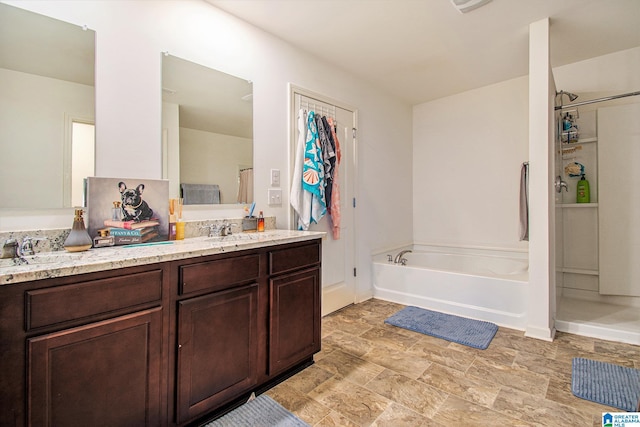 bathroom featuring walk in shower, vanity, and a garden tub