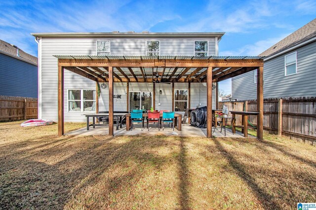 rear view of property featuring a yard, a pergola, a patio, and fence