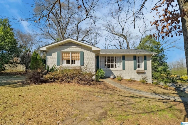 ranch-style home with a front yard and brick siding