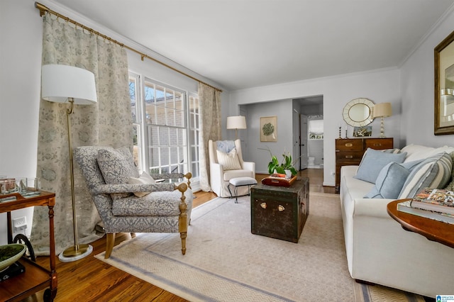 living area featuring wood finished floors and ornamental molding