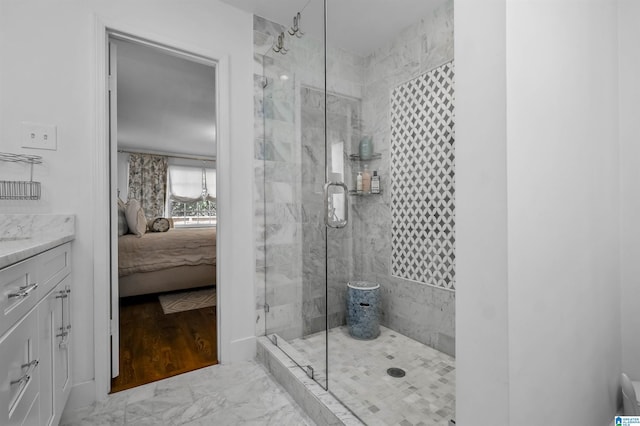 bathroom featuring marble finish floor, a stall shower, and ensuite bathroom