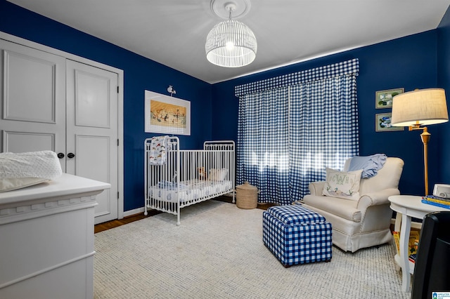 bedroom featuring a closet and a nursery area