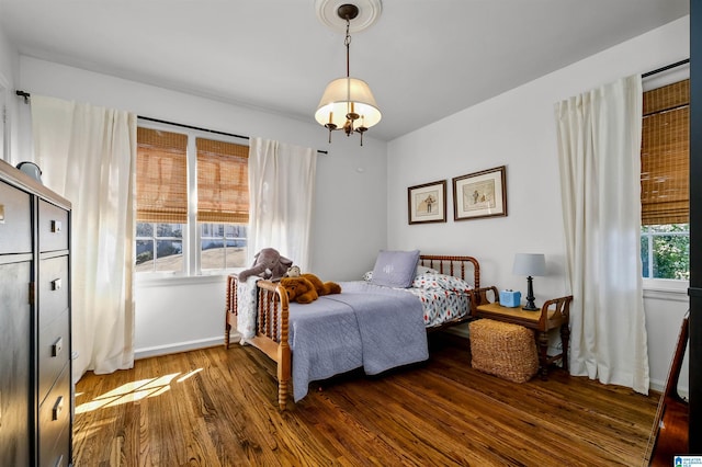 bedroom with baseboards and wood finished floors