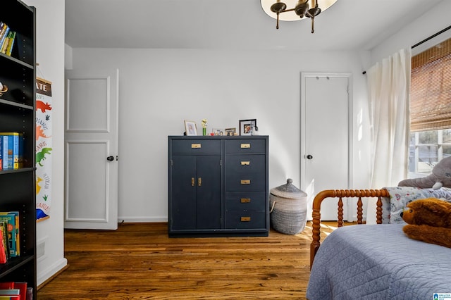 bedroom with baseboards and wood finished floors